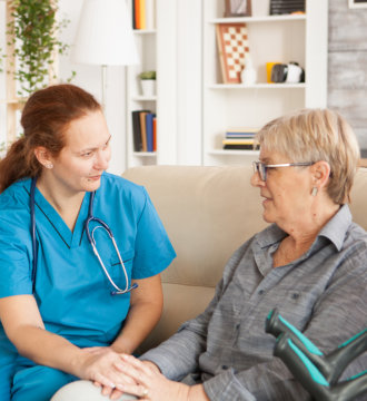 Elderly woman and female nurse talking each other