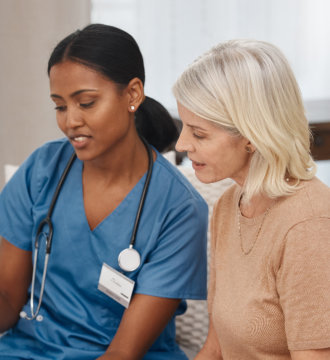 Elderly woman and female nurse talking