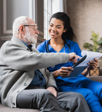 Elderly man and female nurse with stethoscope talking