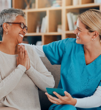 Elderly woman happily talking to her carer