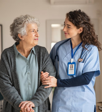 Elderly woman and female nurse looking at each other