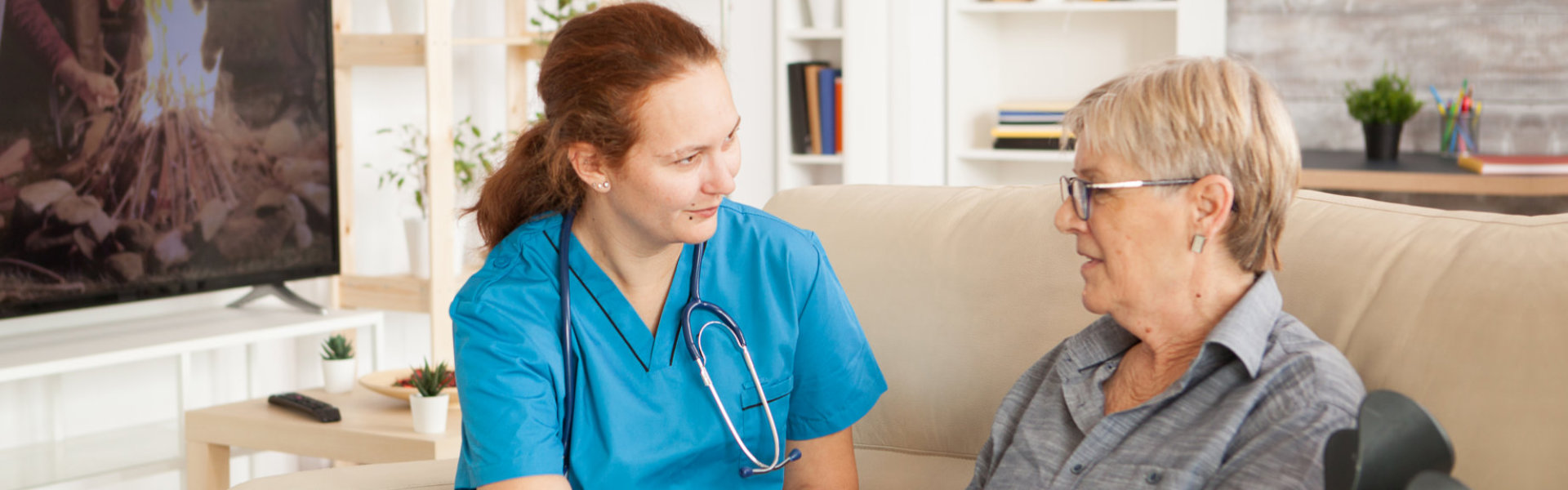 Elderly woman and female nurse talking each other