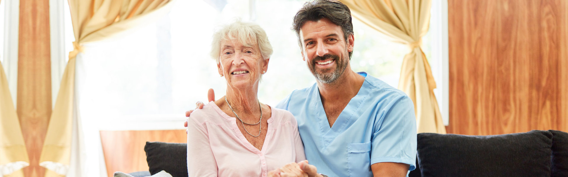 Male nurse and elderly woman smiling at the camera